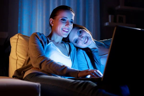 GIrlfriends on a sofa with laptop — Stock Photo, Image