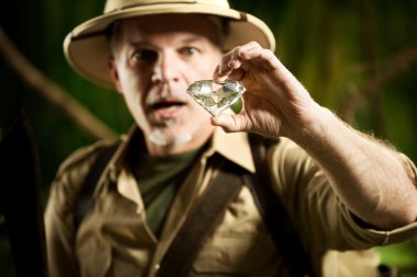 Explorer finding a huge gem in the jungle clipart