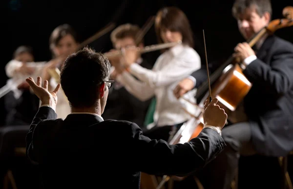 Conductor directing symphony orchestra — Stock Photo, Image