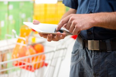 Mağazada tablet kullanan adam