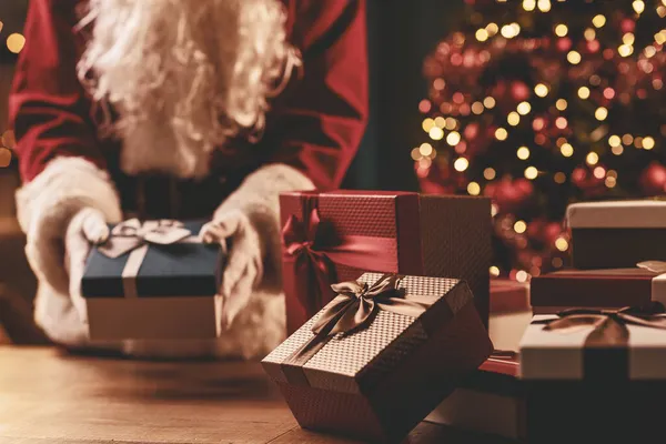 Kerstman Zet Kerstcadeaus Een Tafel Vakantie Viering Concept — Stockfoto