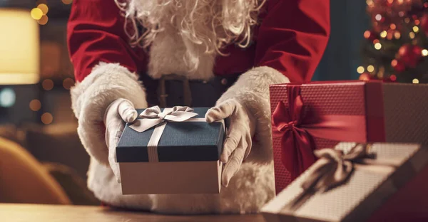 Άγιος Βασίλης Βάζοντας Χριστουγεννιάτικα Δώρα Ένα Τραπέζι Διακοπές Και Γιορτή — Φωτογραφία Αρχείου