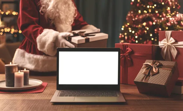 Weihnachtsmann Bringt Weihnachtsgeschenke Und Laptop Mit Leerraum — Stockfoto