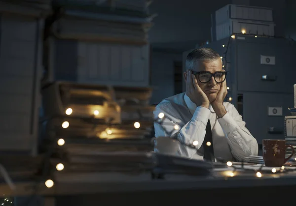 悲しい挫折したビジネスマンは机に座ってクリスマスの日に働く — ストック写真