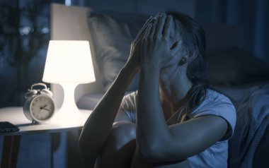 Umutsuz genç kadın gece geç saatte uyanık, uyuyamıyor ve kötü bir baş ağrısı, uykusuzluk ve stres konsepti var. 