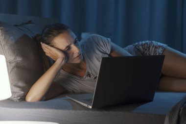 Geceleri yatakta uzanan ve bilgisayarına bağlanan bir kadın uyuyamıyor.