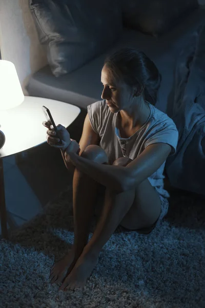 Mujer Agotada Sentada Junto Cama Revisando Teléfono Inteligente Tarde Noche —  Fotos de Stock
