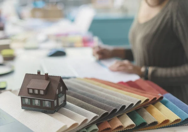 Innenarchitektin Sitzt Schreibtisch Und Arbeitet Stoffmuster Und Modellhaus Vordergrund Selektiver — Stockfoto