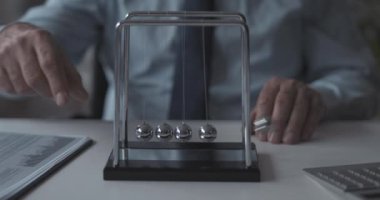 İş adamı Newton 'un beşik denge toplarıyla oynuyor