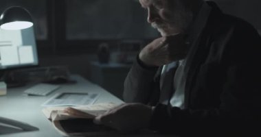 İşadamı gazetedeki borsa haberlerini kontrol ediyor.