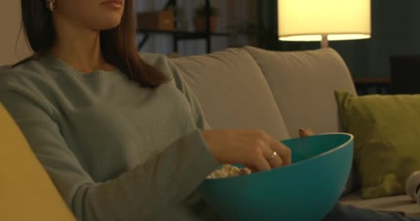 Adolescente comiendo palomitas de maíz y viendo la televisión — Vídeo de stock