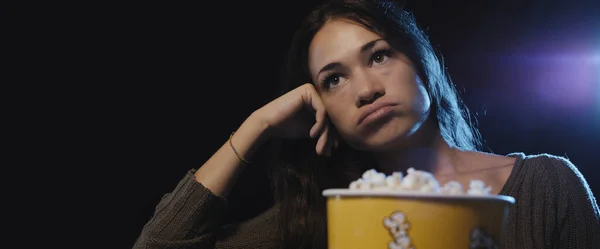 映画館で退屈な映画を見て失望した女性 — ストック写真