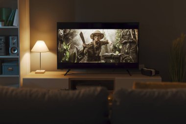 Geniş ekran TV ve oturma odasındaki heyecanlı macera filmi