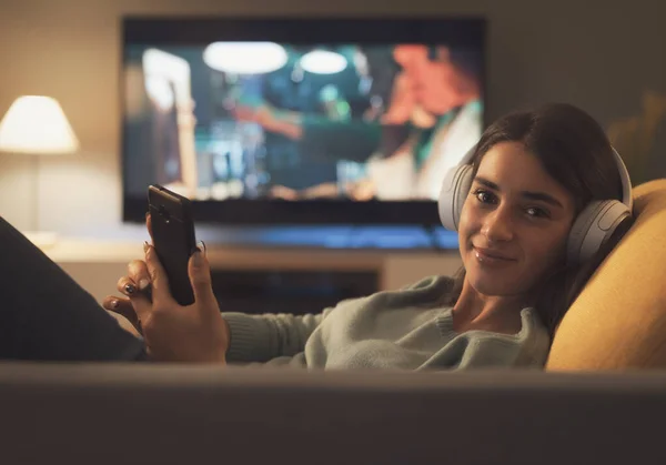 Young Woman Lying Couch She Connecting Her Smartphone Looking Camera — Stock Fotó