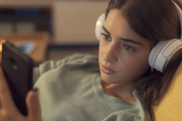 Young Woman Lying Couch Relaxing She Wearing Headphones Connecting Her — стоковое фото