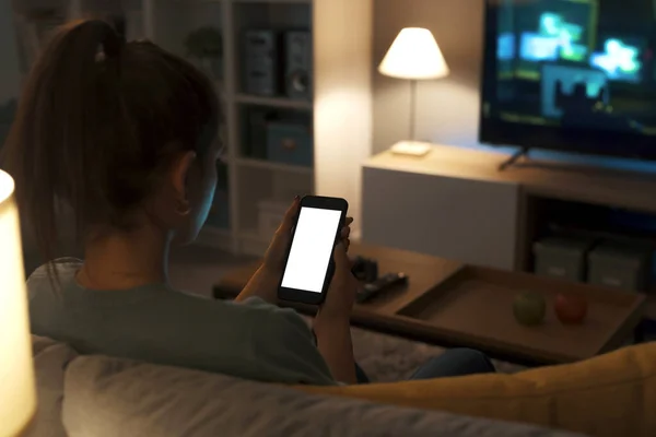 Ergen Evdeki Kanepede Dinleniyor Akıllı Telefonunu Kullanarak Internete Bağlanıyor — Stok fotoğraf