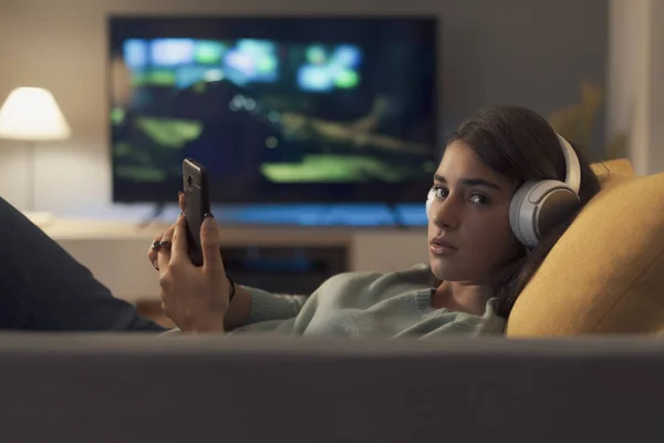 Young Woman Lying Couch She Connecting Her Smartphone Looking Camera — Stock Fotó
