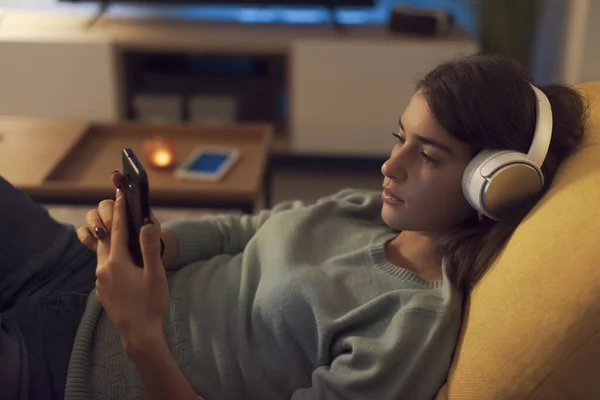 Young Woman Lying Couch Relaxing She Wearing Headphones Connecting Her — 스톡 사진