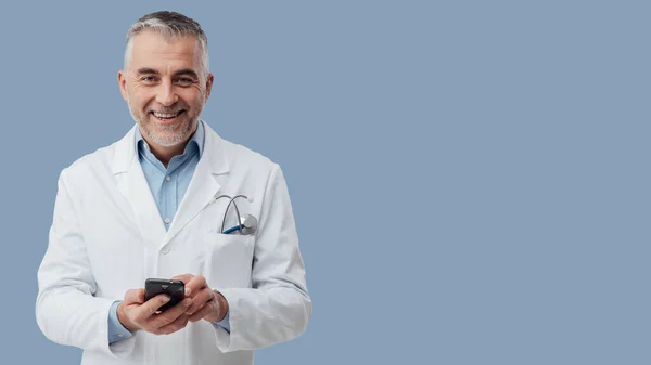 Smiling Mature Doctor Connecting His Smartphone Doing Medical Consultation Online — Zdjęcie stockowe