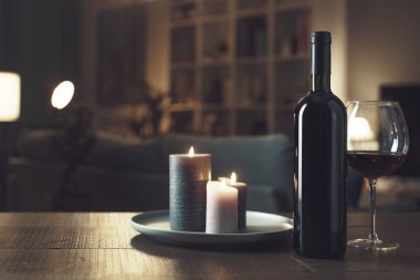 Romantik şarap tatma, yanan mumlar ve oda içi.