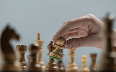 Profesyonel oyuncu satranç tahtasında, satranç oyununda ve strateji konseptinde piyon taşıyor