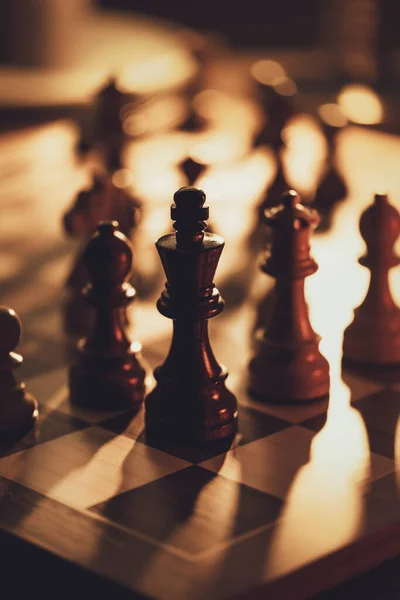 チェスの駒チェスボードと黄金の薄暗い光 チェスゲームと戦略の概念 — ストック写真