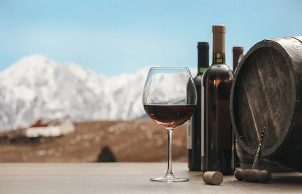 红酒的味道 酒瓶和酒桶放在桌子上 背景是高山全景 — 图库照片