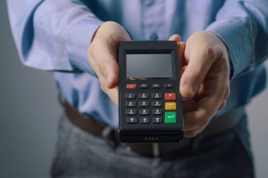 İş adamı POS terminali gösteriyor, elektronik ödeme kavramı
