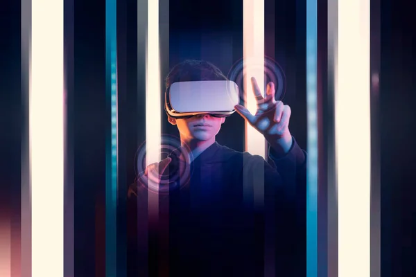Teenager wearing a VR headset and using a touch screen interface in a virtual environment