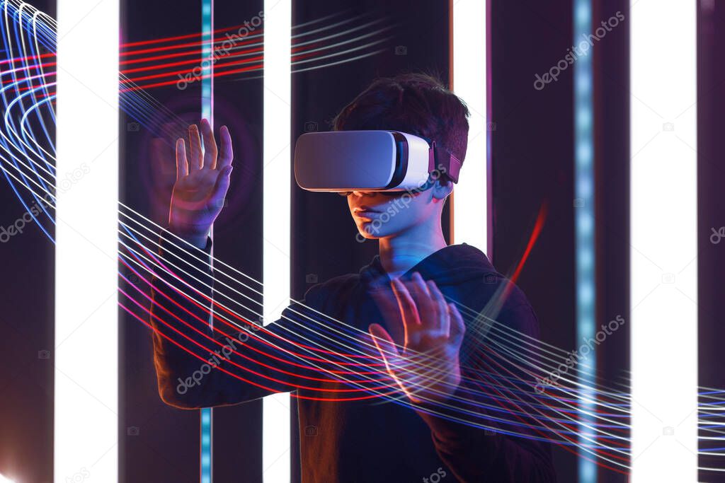 Teenager wearing a VR headset and experiencing virtual reality, metaverse and VR concept