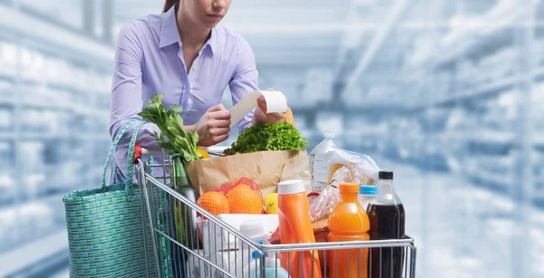 Vrouw Duwen Een Kar Het Controleren Van Een Boodschappenkwitantie Boodschappen — Stockfoto