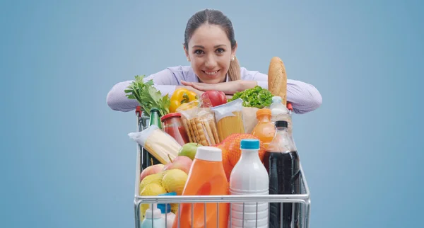 Mosolygó Fiatal Támaszkodik Egy Teljes Bevásárlókocsi Pózol Élelmiszer Vásárlási Koncepció — Stock Fotó
