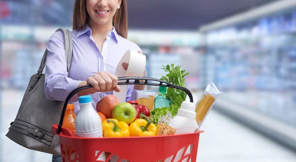 Sorrindo Jovem Mulher Fazendo Compras Supermercado Ela Está Segurando Uma — Fotografia de Stock