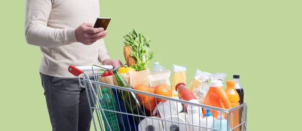 Hombre Empujando Carrito Compras Utilizando Teléfono Inteligente Compras Comestibles Concepto — Foto de Stock