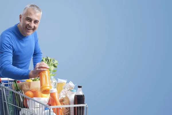 Vrolijke Volwassen Man Zet Goederen Winkelwagen Glimlachende Kruidenierswinkel Banner — Stockfoto