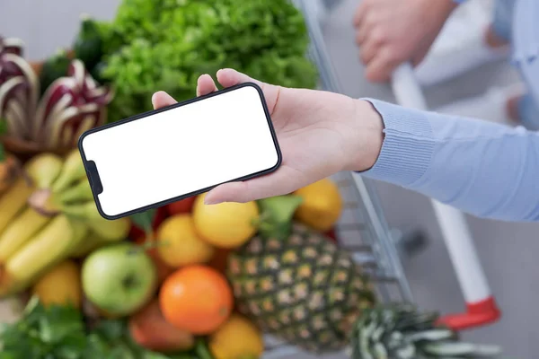 Donna Che Spesa Usando Suo Smartphone Suo Carrello Pieno Frutta — Foto Stock