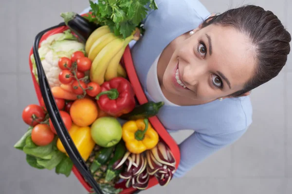 Młoda Kobieta Trzyma Koszyk Pełen Świeżych Warzyw Owoców Uśmiecha Się — Zdjęcie stockowe