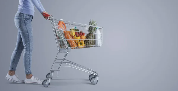 フルショッピングカート スーパーマーケット 食料品のショッピングバナー 空白のコピースペースを押す若い女性 — ストック写真