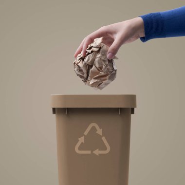 Çöp kutusuna buruşmuş kağıt koyan kadın geri dönüşüm ve atık ayıklama kavramı