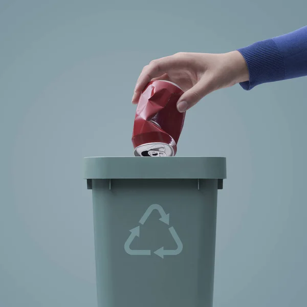 ゴミ箱に缶を入れる女性廃棄物の収集とリサイクルの概念 — ストック写真