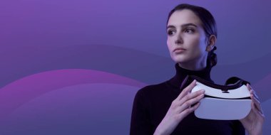 Çekici genç bir kadın, elinde bir VR kulaklığı tutuyor ve başka tarafa bakıyor, sanal gerçeklik ve metazıt konsept