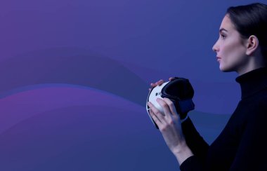 Elinde bir VR kulaklık tutan ve sanal gerçekliğe erişen genç bir kadın. Arka planda soyut dalgalar, metazet ve sanal gerçeklik kavramı.