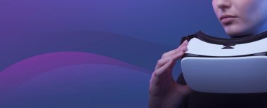 Kendine güvenen bir kadın VR kulaklığı tutuyor ve başka tarafa bakıyor: sanal gerçeklik, metaevren ve simülasyon konsepti