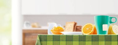 Evde çay, meyve, ekmek ve reçelli sağlıklı bir kahvaltı.