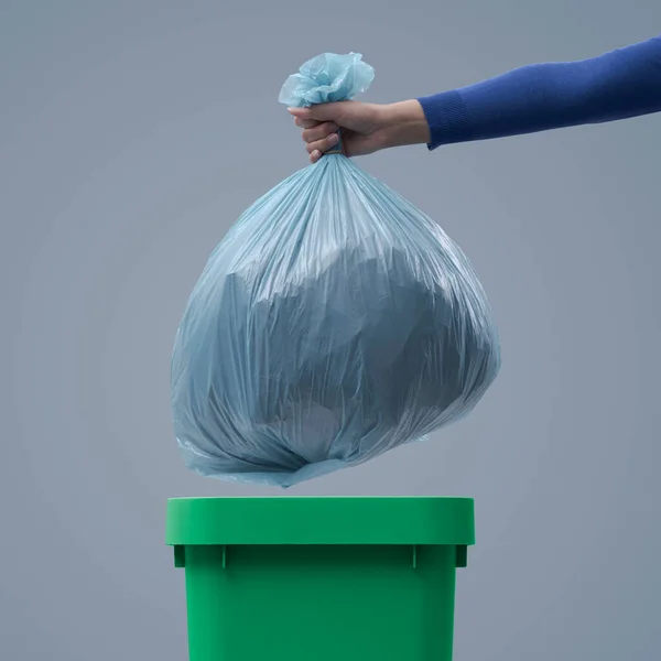女人把一个巨大的垃圾袋放进垃圾箱 没有区别的废物概念 — 图库照片