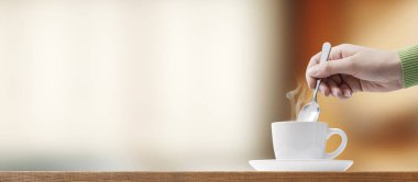 Kahve molası veren bir kadın: Kahve karıştırıyor.