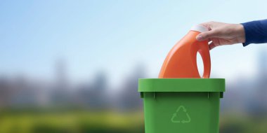 Kadın çöp kutusuna plastik deterjan şişesi geri dönüşüm konsepti, arka planda doğal manzara.