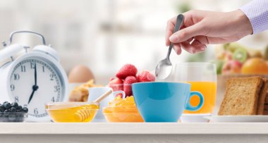 Evde nefis bir kahvaltı yapan kadın, çay yapıyor.