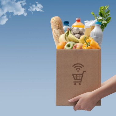 Çevrimiçi market alışverişi ve ev teslimat servisi: bakkaliye paketi taşıyan işçi