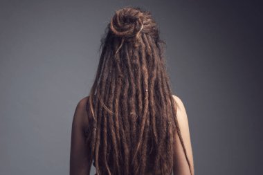 Genç bir kadının yakın plan portresi. Rasta ve uzun saç arkası.